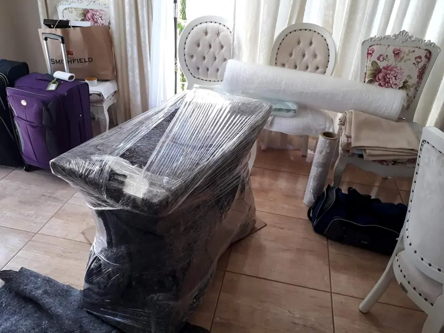 Móvel envolvido em filme plástico de proteção em sala de jantar durante mudança residencial