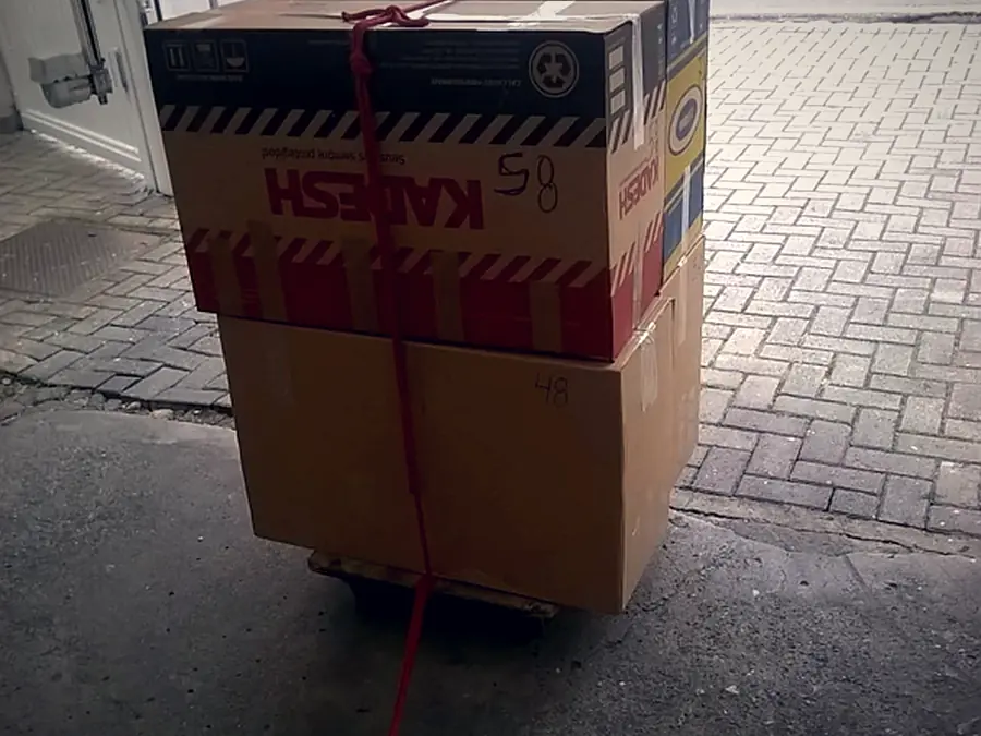 Caixas de papelão resistentes amarradas com corda sobre carrinho de transporte da Japan Mudanças