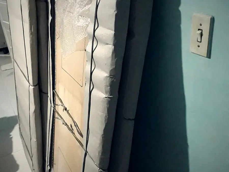Móveis desmontados e protegidos com papelão e plástico, prontos para o transporte pela Japan Mudanças
